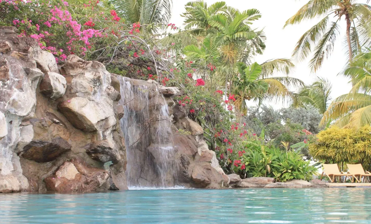 Pool waterfall with palms and lounge chairs at Radisson Grenada Beach Resort.
