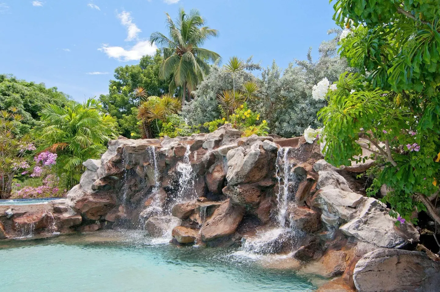 Rock waterfall and tropical landscaping by the pool at Radisson Grenada Beach Resort.