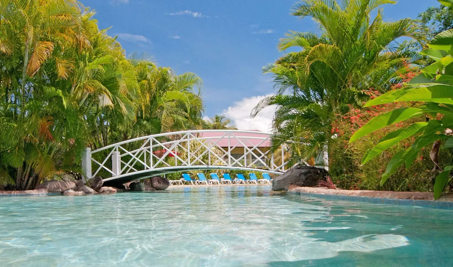 White footbridge over the tropical pool at Radisson Grenada Beach Resort.