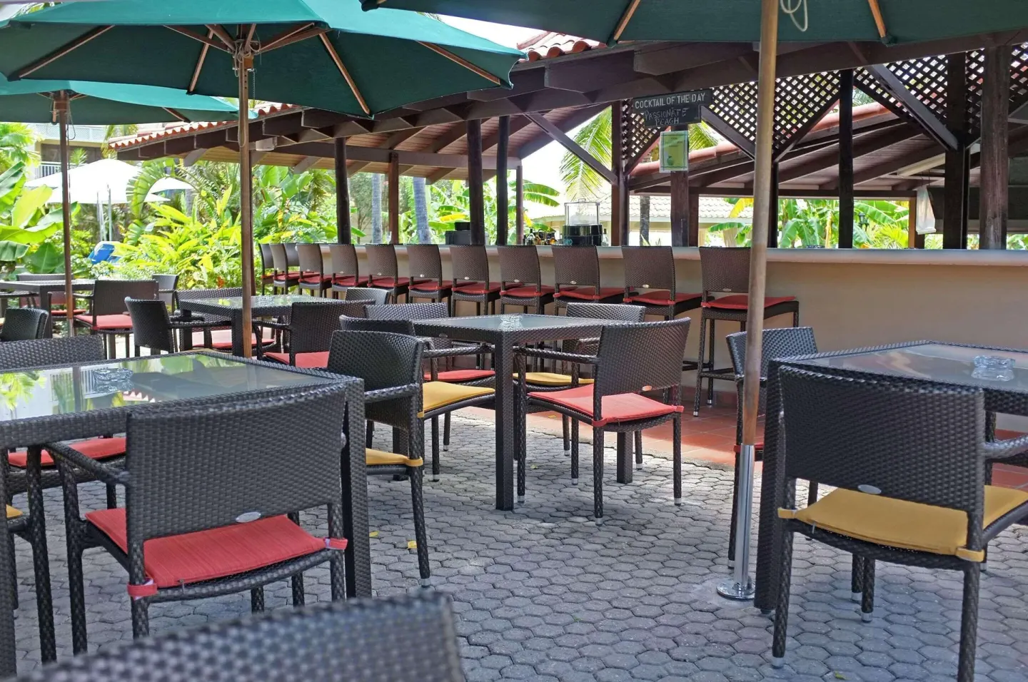 Covered outdoor bar seating with umbrellas at Radisson Grenada Beach Resort.