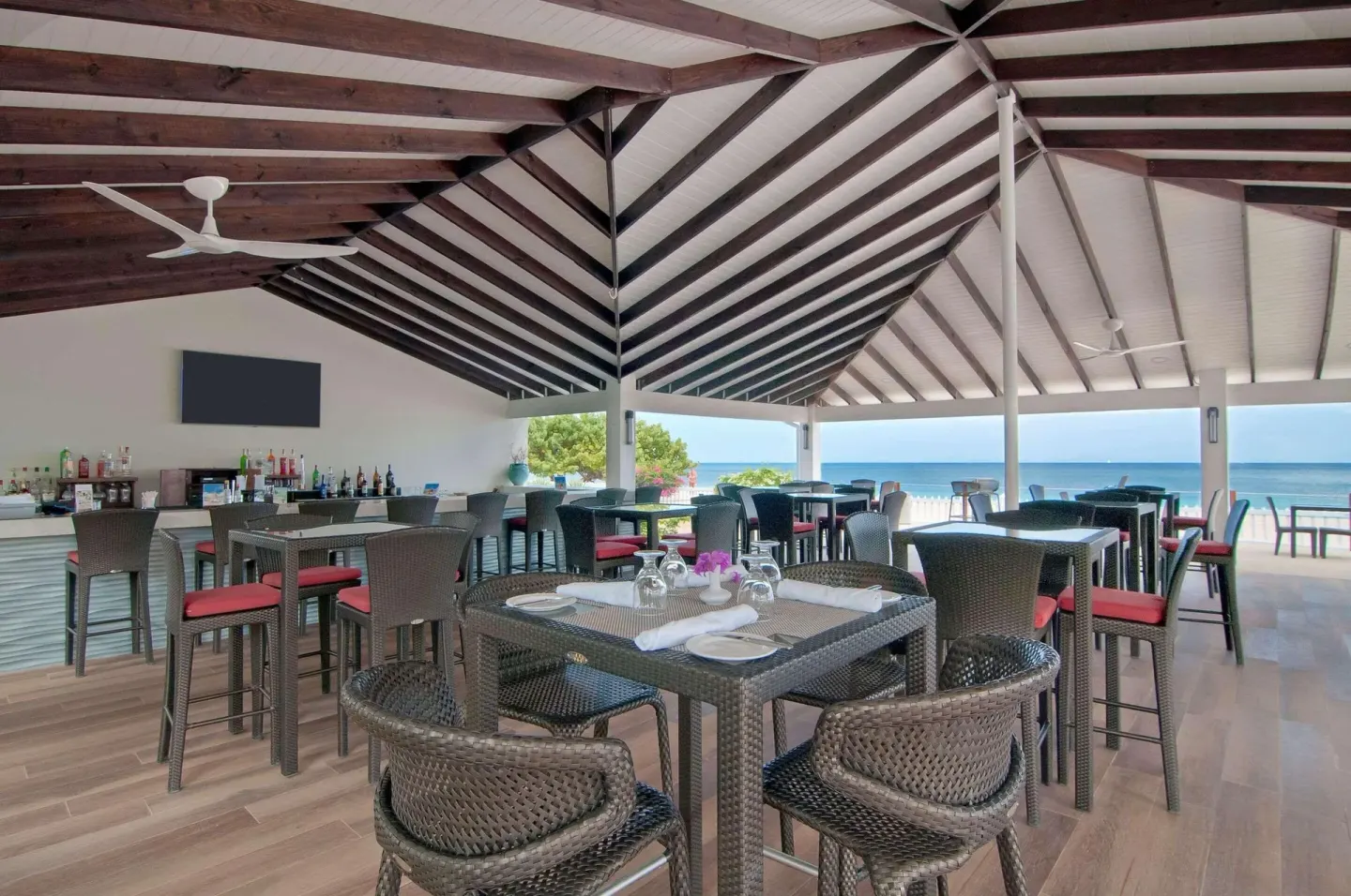 Open-air restaurant and bar with ocean view at Radisson Grenada Beach Resort.