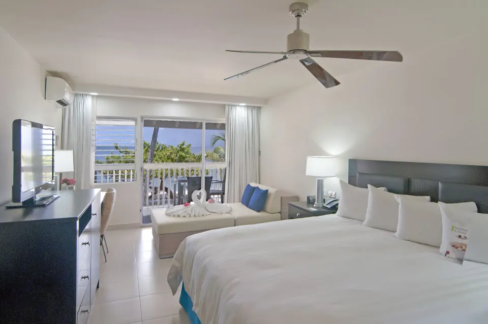 Non Smoking Garden View king room with TV and balcony at Radisson Grenada Beach Resort.