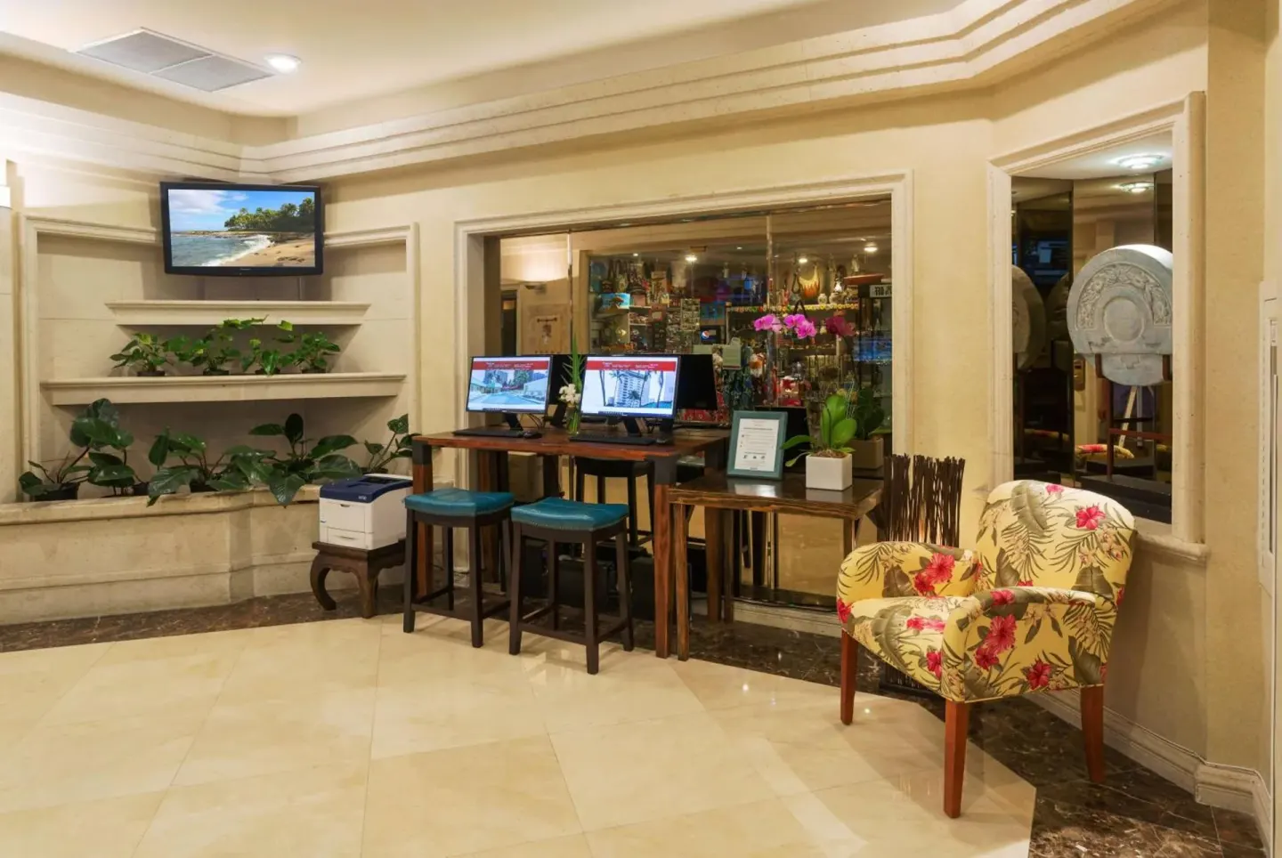 Lobby computer area with seating and plants at Ramada Plaza Waikiki.