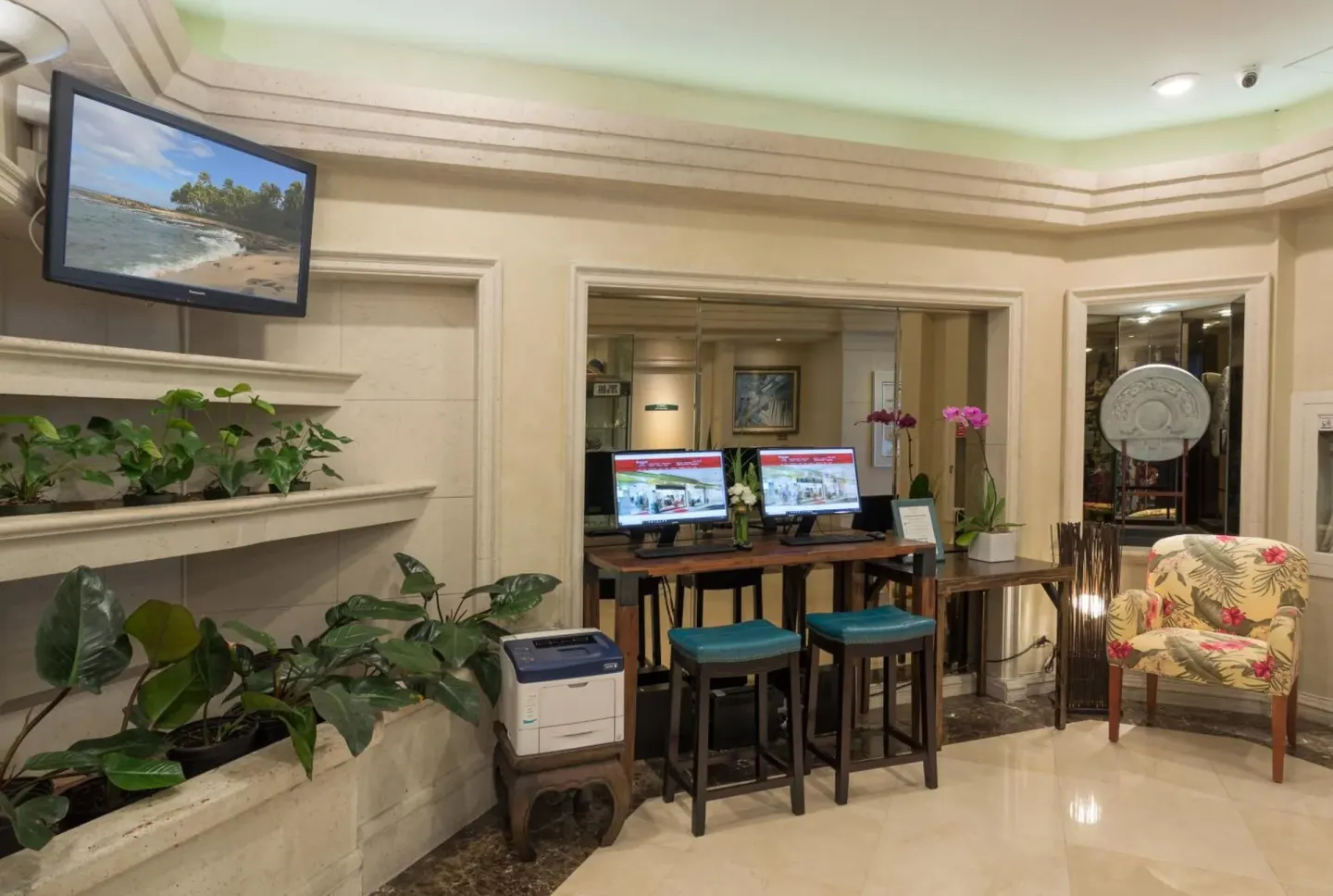 Lobby computer station with plants and seating at Ramada Plaza Waikiki.
