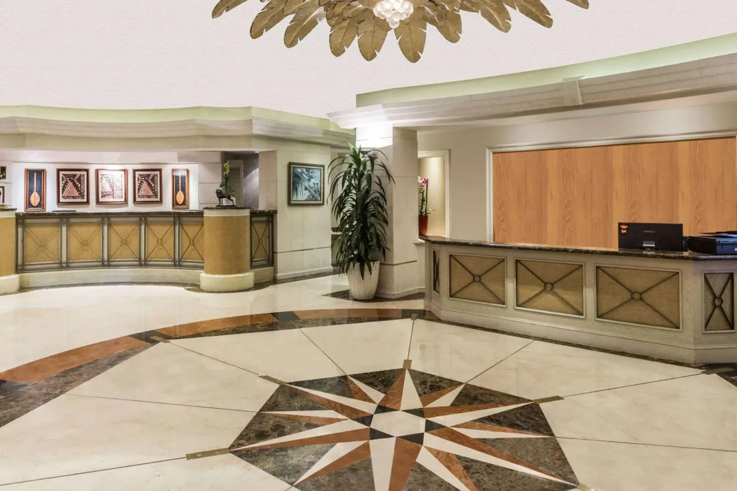 Lobby front desk area with compass floor inlay at Ramada Plaza Waikiki.