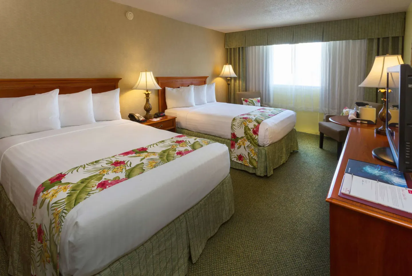Standard Room with two double beds, desk, TV and curtained window at Ramada Plaza Waikiki.