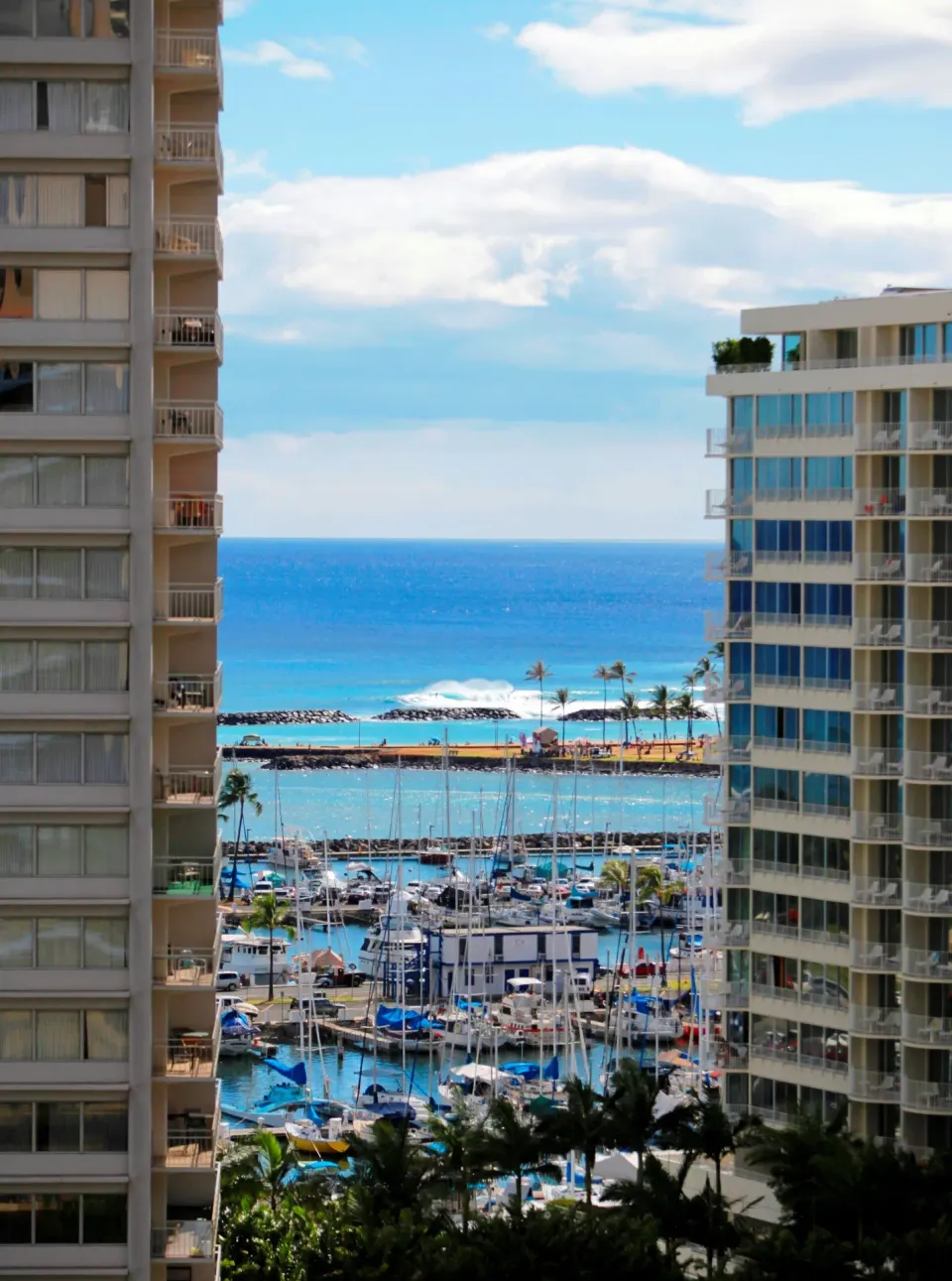 Ocean, marina, and beach view between buildings at Ramada Plaza Waikiki.