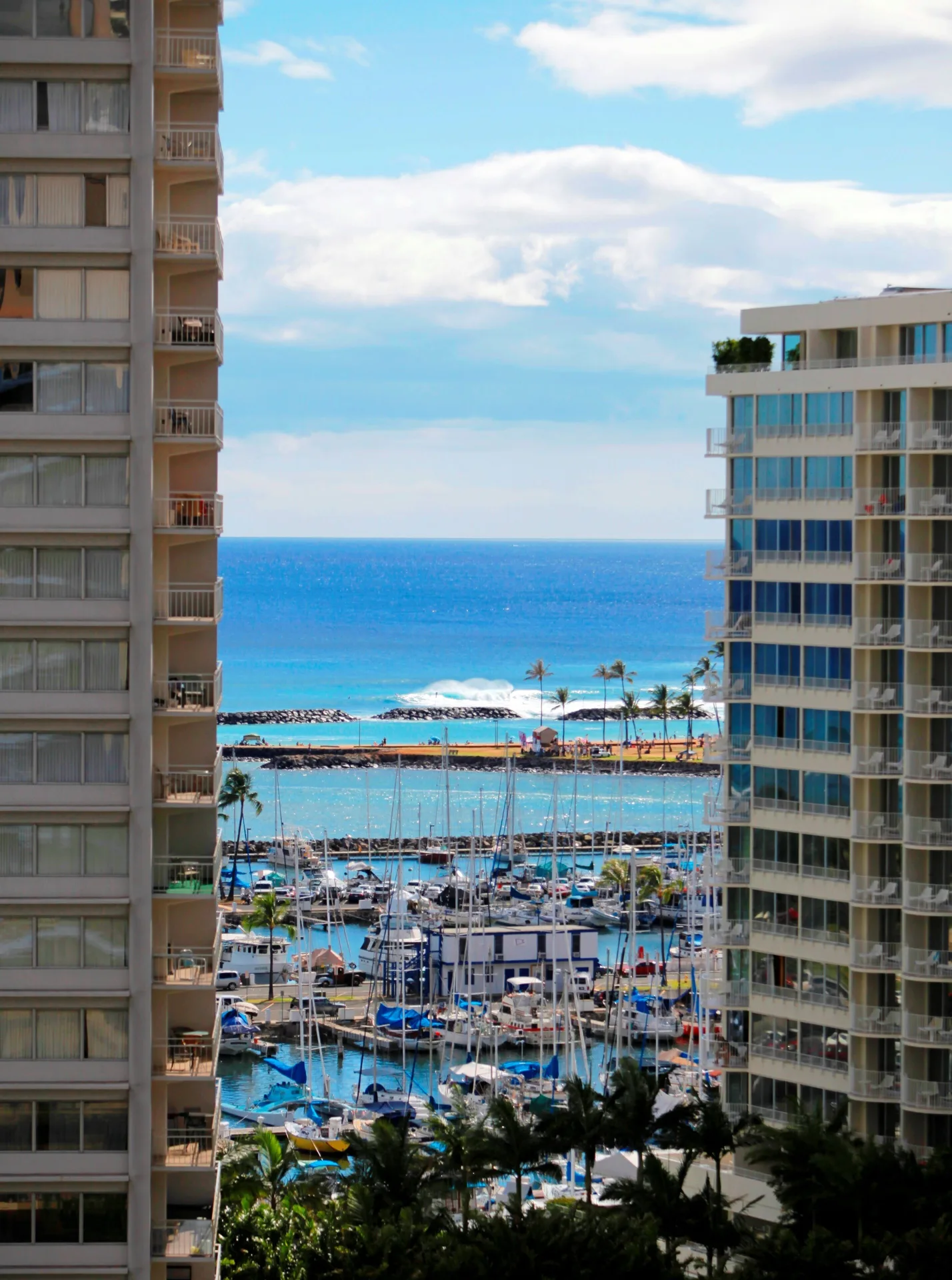Ocean, marina, and beach view between buildings at Ramada Plaza Waikiki.