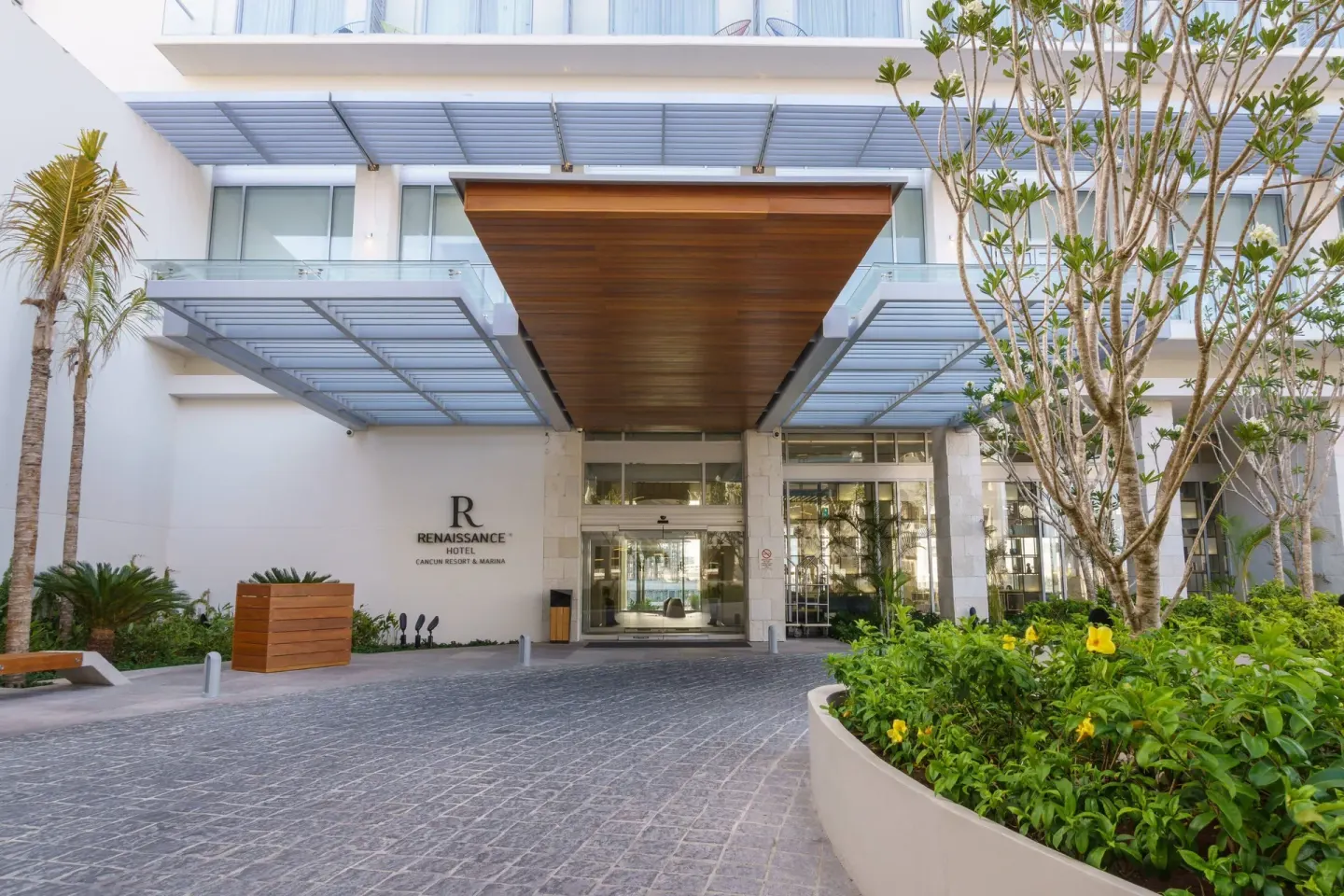 Covered main entrance driveway at Renaissance Cancun Resort & Marina with landscaping and glass doors.