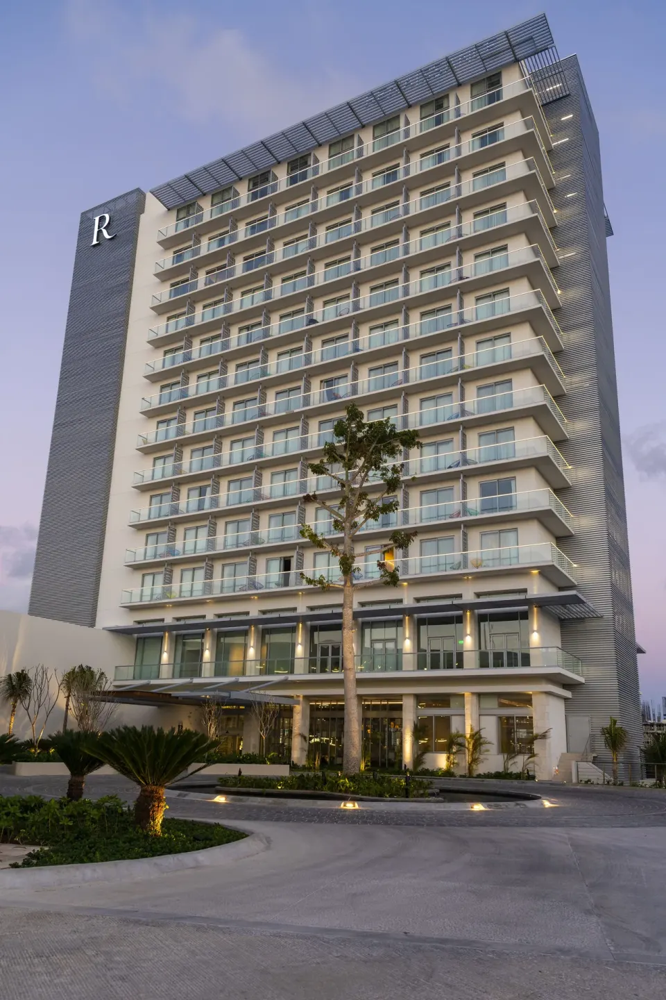 Exterior tower with balconies and landscaped drive at Renaissance Cancun Resort & Marina.
