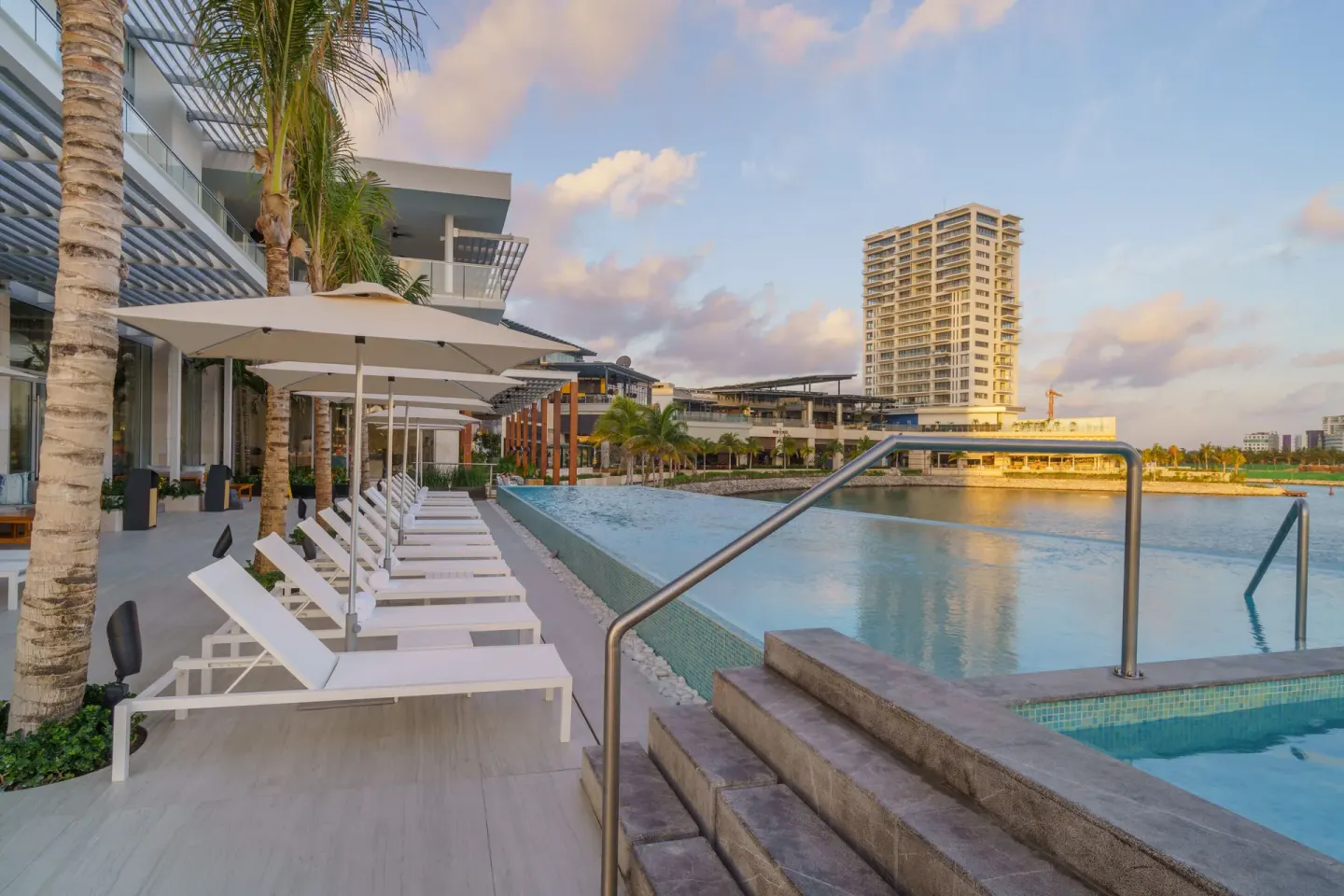 Infinity pool with loungers and marina views at Renaissance Cancun Resort & Marina.