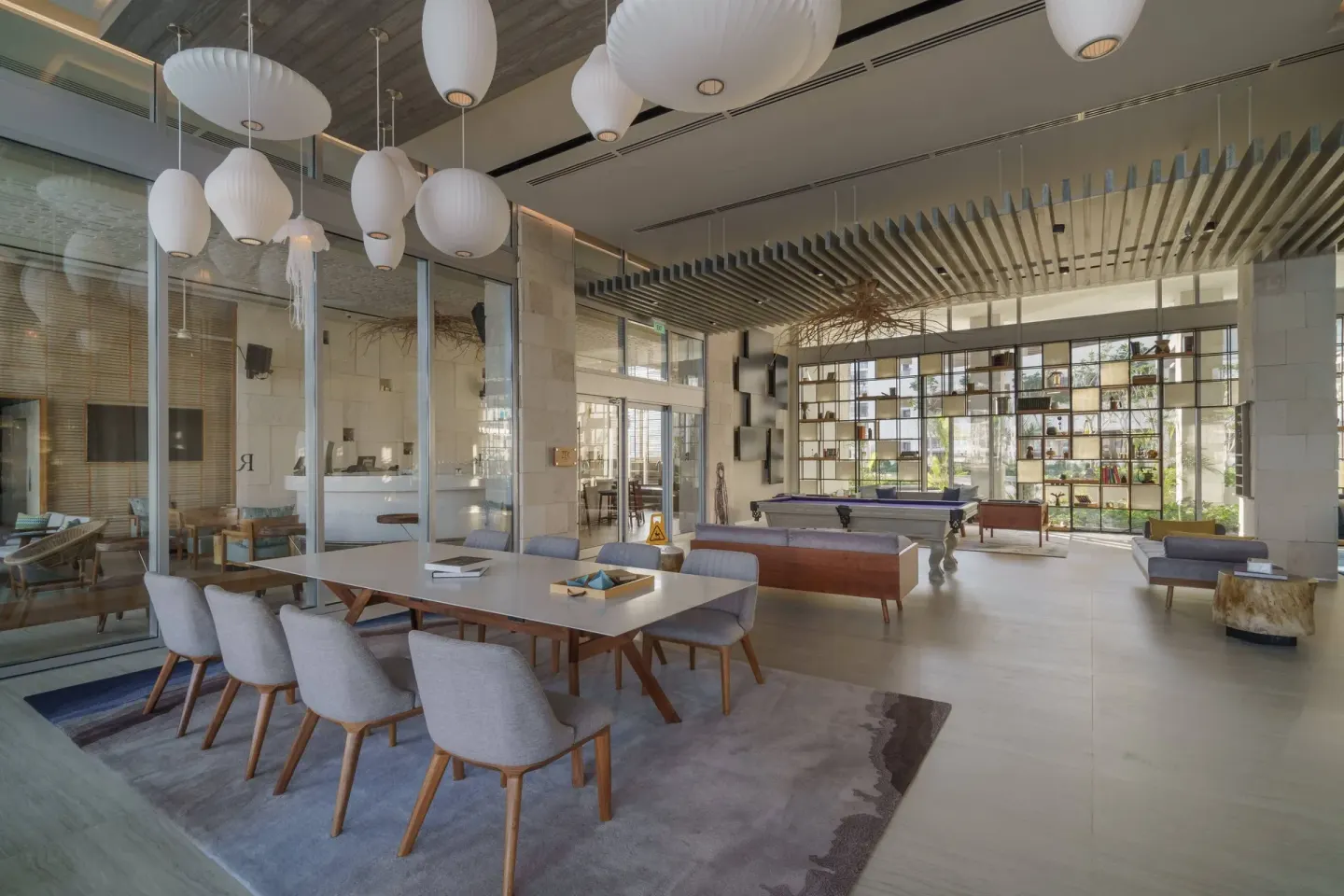 Lobby lounge at Renaissance Cancun Resort & Marina with tables, pendant lights, seating, and a pool table.