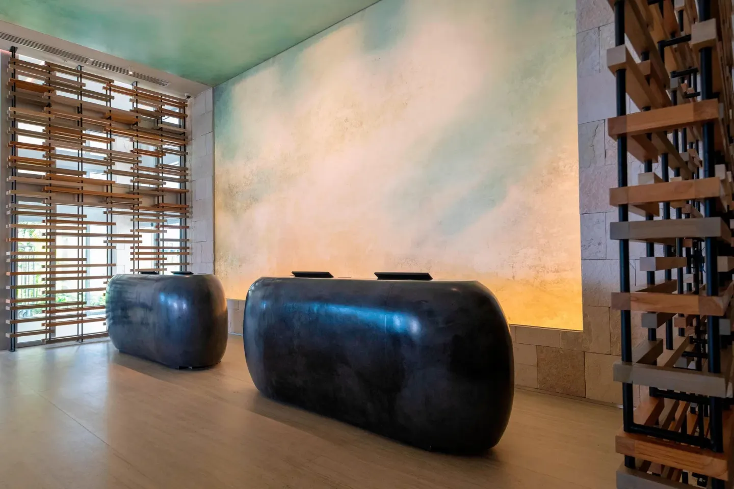 Reception area at Renaissance Cancun Resort & Marina with sculptural black desks and wood screens.