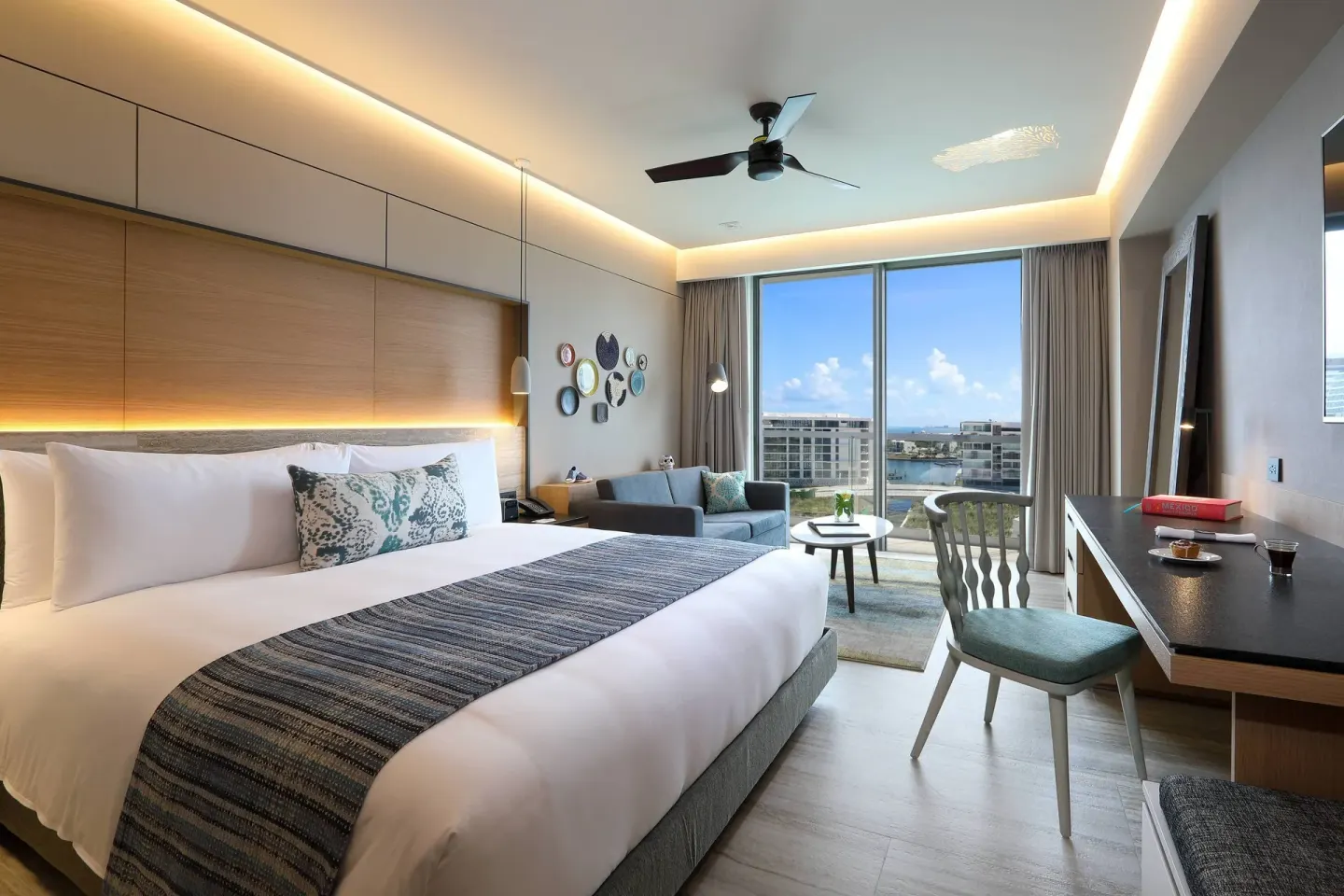 Deluxe balcony room with king bed, sofa bed, desk, and marina view at Renaissance Cancun Resort & Marina.