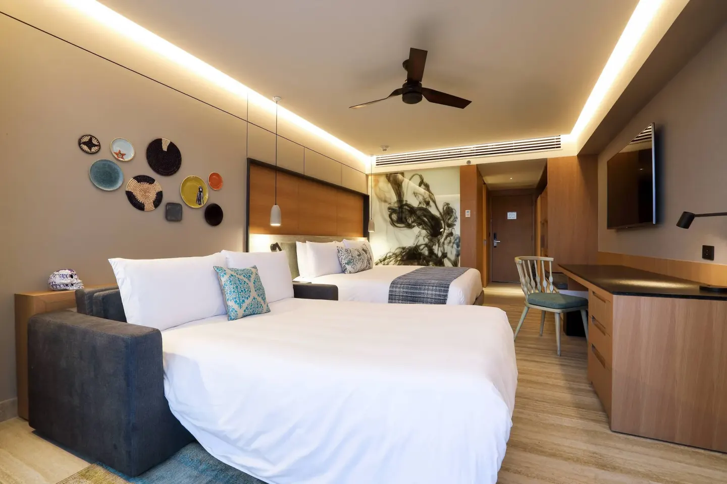 Deluxe room with two beds, sofa bed, desk, and TV at Renaissance Cancun Resort & Marina.