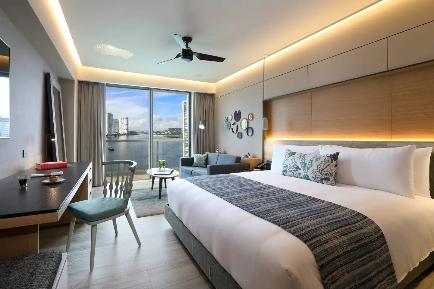 King room with sofa bed, desk, and balcony marina view at Renaissance Cancun Resort & Marina.