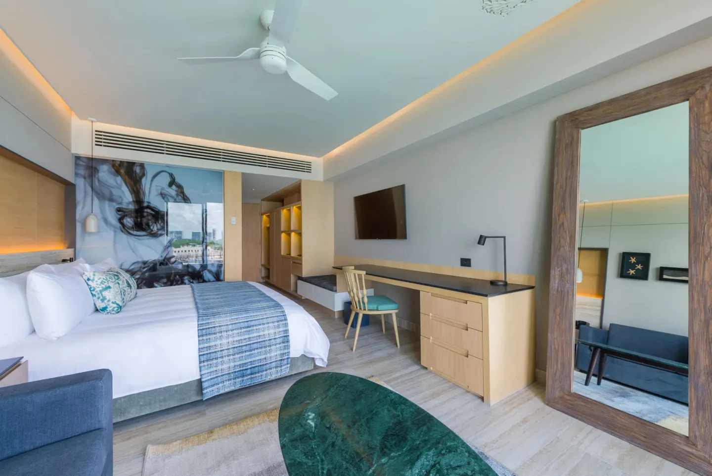 Ocean-view room with king bed, sofa, desk, and mirror at Renaissance Cancun Resort & Marina.