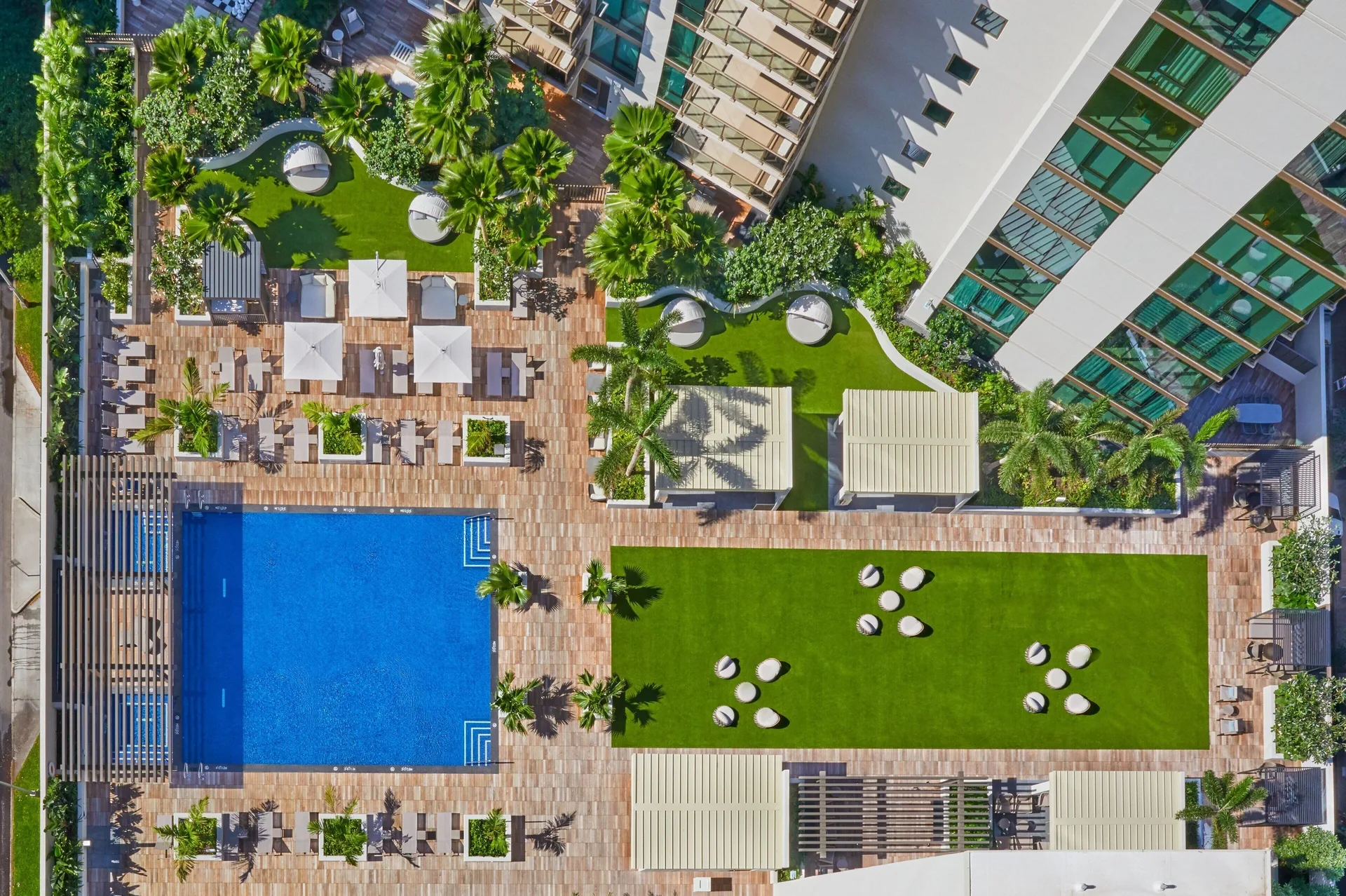 Aerial view of pool deck, lawns, cabanas, and palms at Renaissance Honolulu Hotel & Spa.