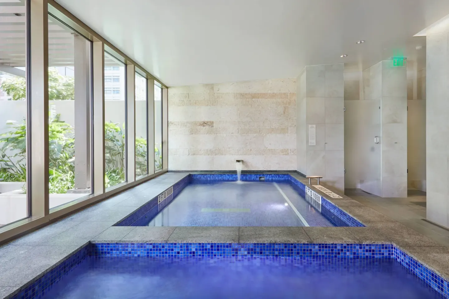 Blue-tiled indoor spa pools with garden windows at Renaissance Honolulu Hotel & Spa.