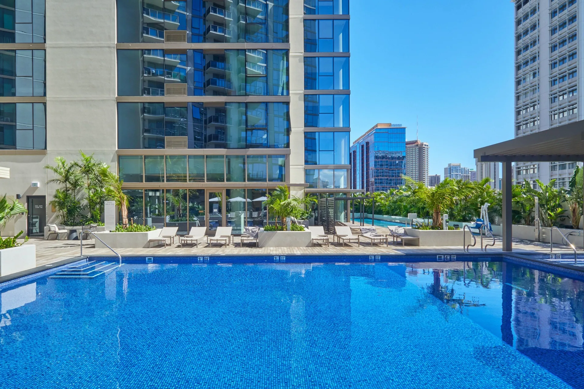 Outdoor pool deck with city towers at Renaissance Honolulu Hotel & Spa.