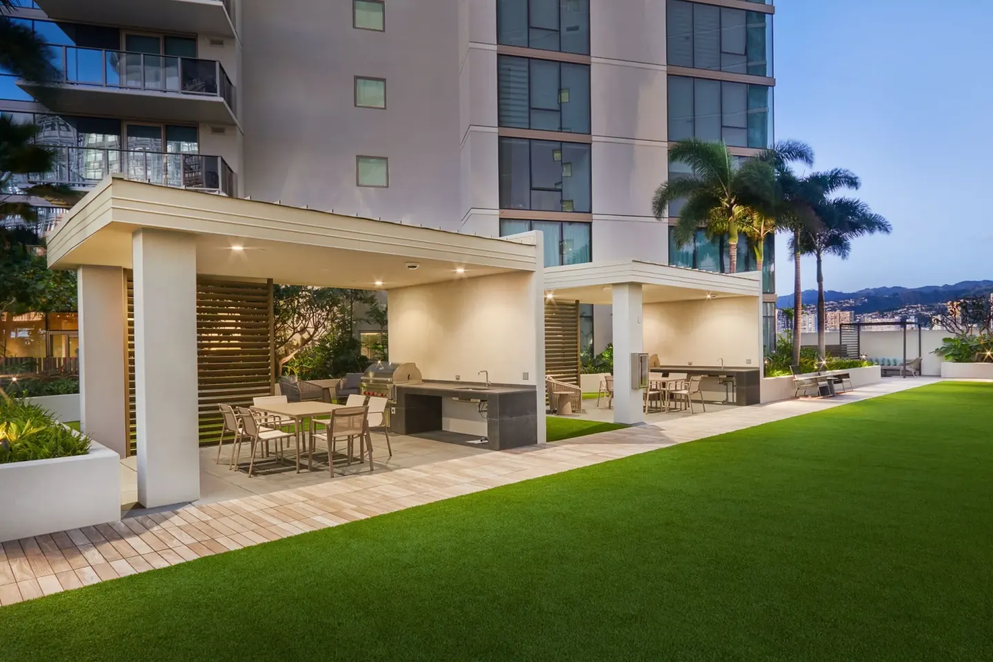 Outdoor terrace with covered seating and a lawn at Renaissance Honolulu Hotel & Spa.