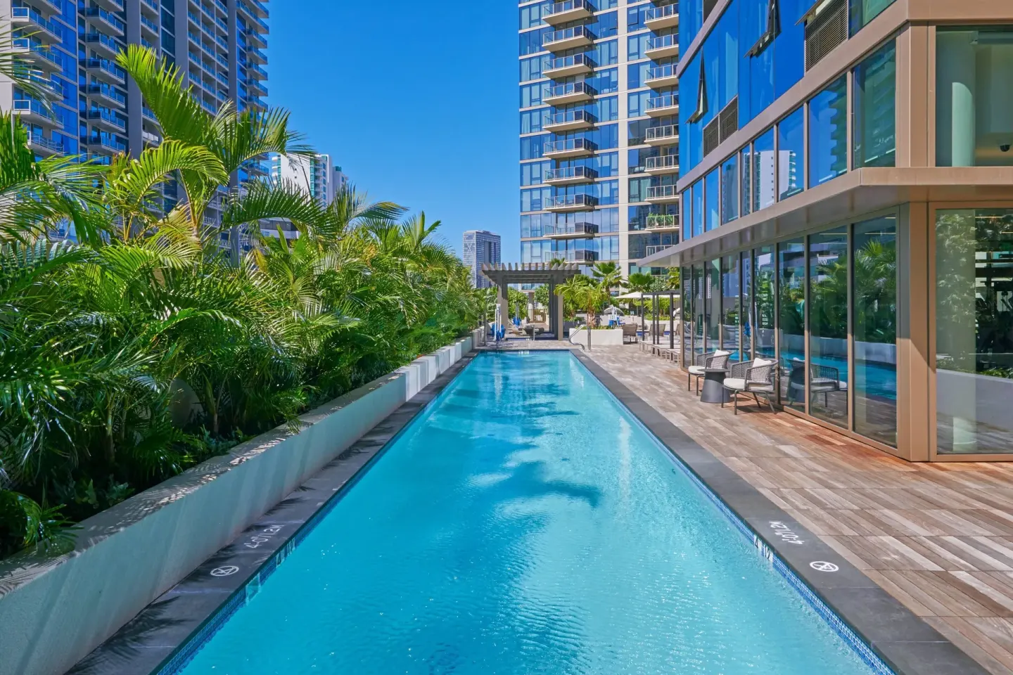 Rooftop lap pool beside palms and glass towers at Renaissance Honolulu Hotel & Spa.