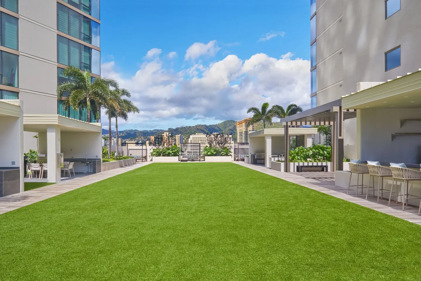 Rooftop lawn with palms and city views at Renaissance Honolulu Hotel & Spa.