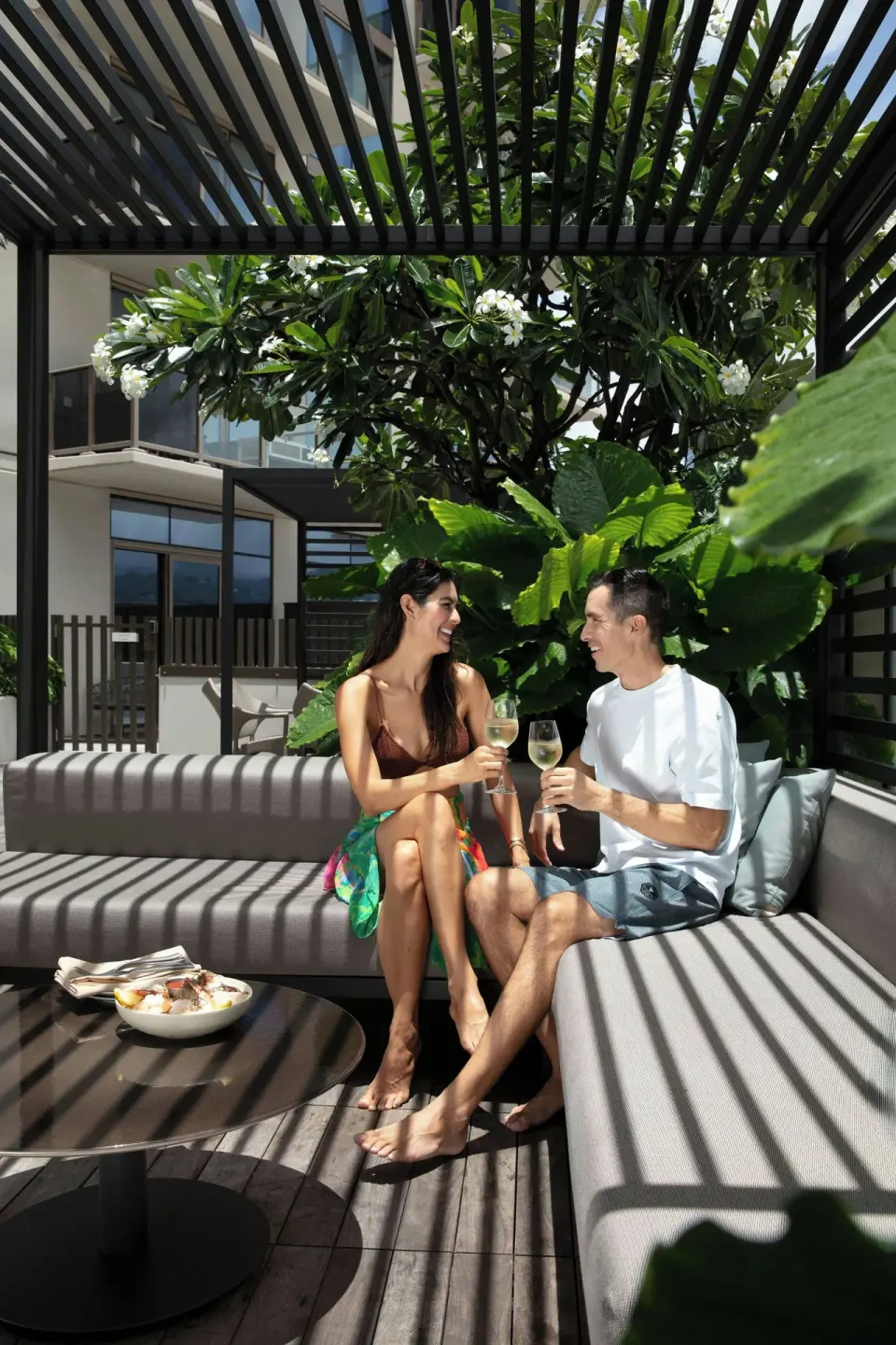 Couple enjoying drinks on a shaded terrace at Renaissance Honolulu Hotel & Spa.