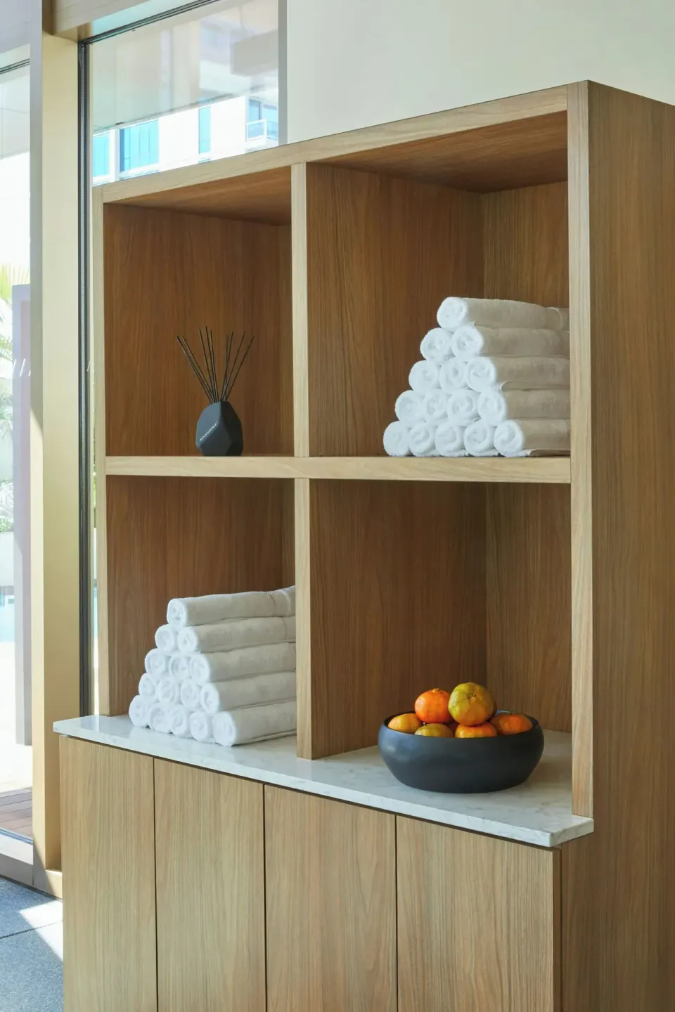 Wood shelving with rolled towels and fruit at Renaissance Honolulu Hotel & Spa.