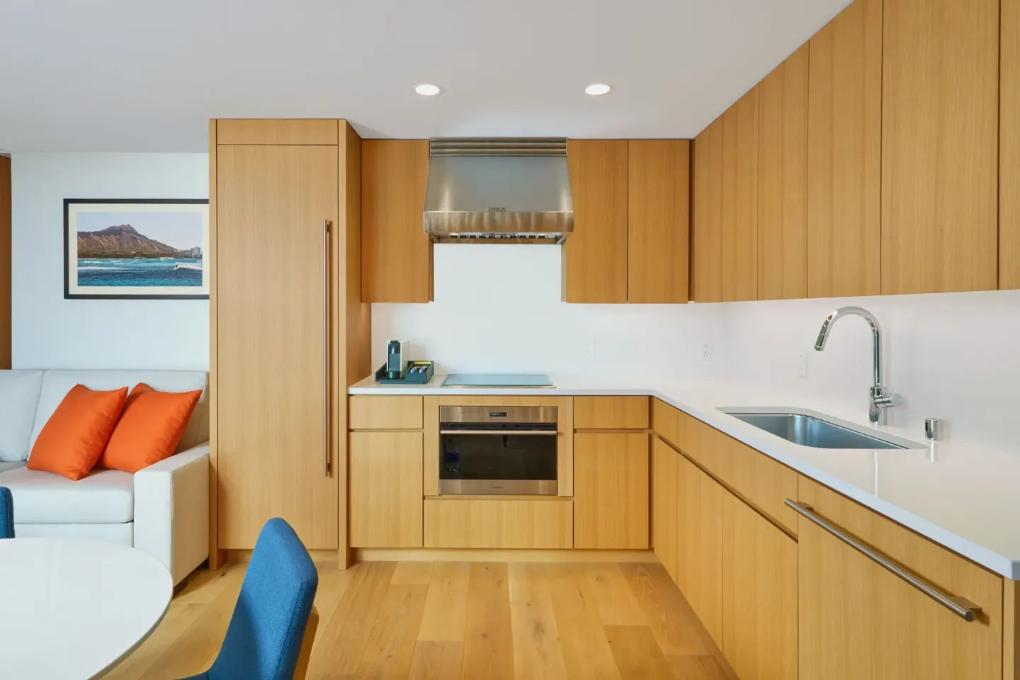 Suite kitchen with wood cabinetry and adjacent sofa at Renaissance Honolulu Hotel & Spa.