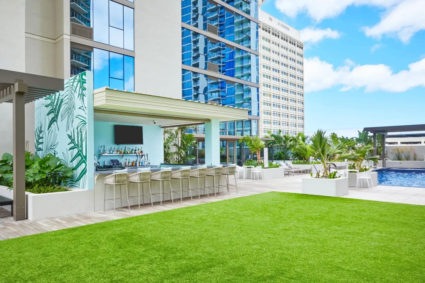 Poolside bar, lawn, palms, and pool deck at Renaissance Honolulu Hotel & Spa.