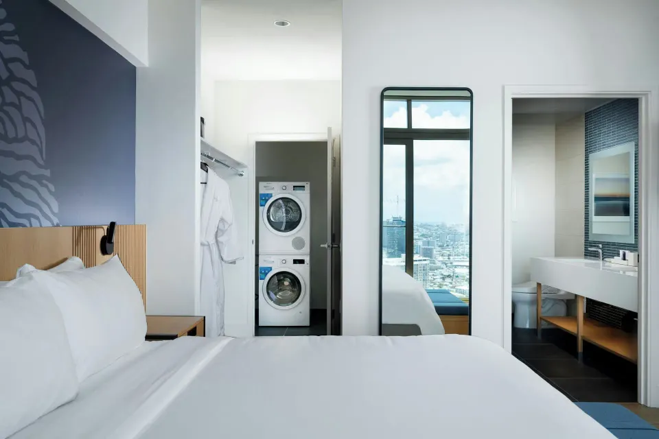 Bedroom with laundry area in the Alani Penthouse suite at Renaissance Honolulu Hotel & Spa.