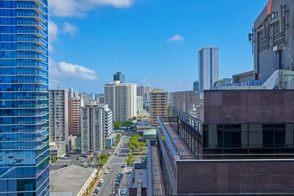 City street and high-rise view from Renaissance Honolulu Hotel & Spa with blue-glass tower nearby.