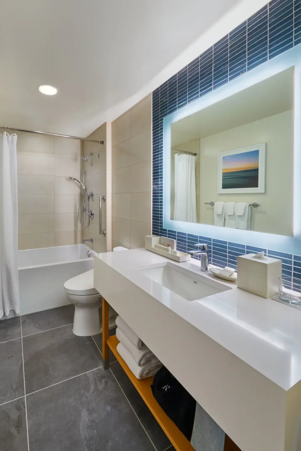 City View Room bathroom with tub shower and illuminated mirror at Renaissance Honolulu Hotel & Spa.