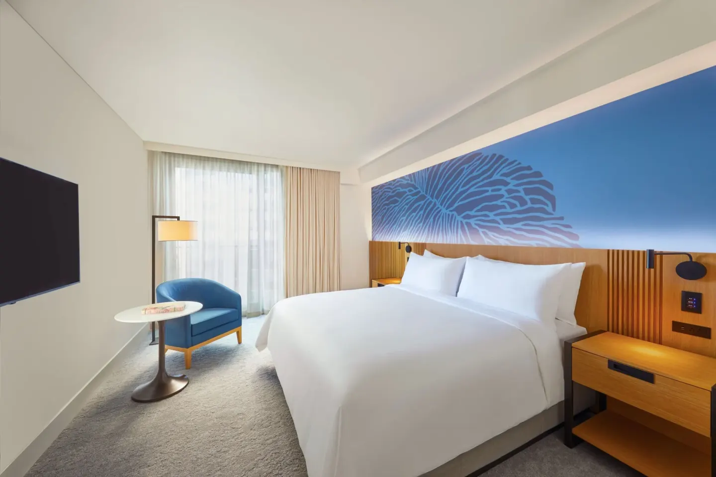 City View Room king bed with blue mural wall and seating area at Renaissance Honolulu Hotel & Spa.