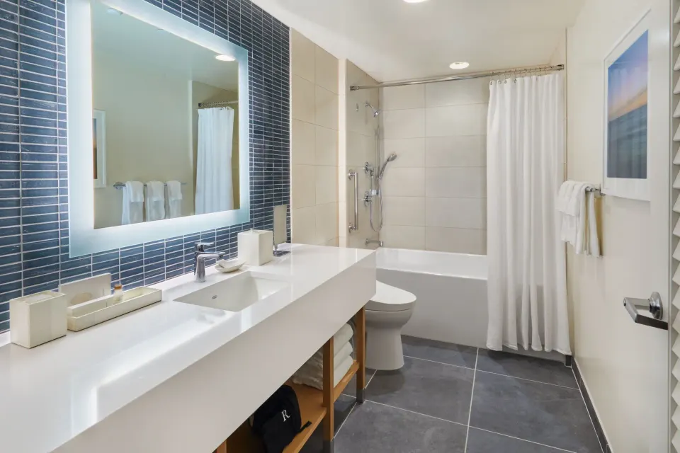 City View guest room bathroom at Renaissance Honolulu Hotel & Spa with vanity, tub, and shower curtain.