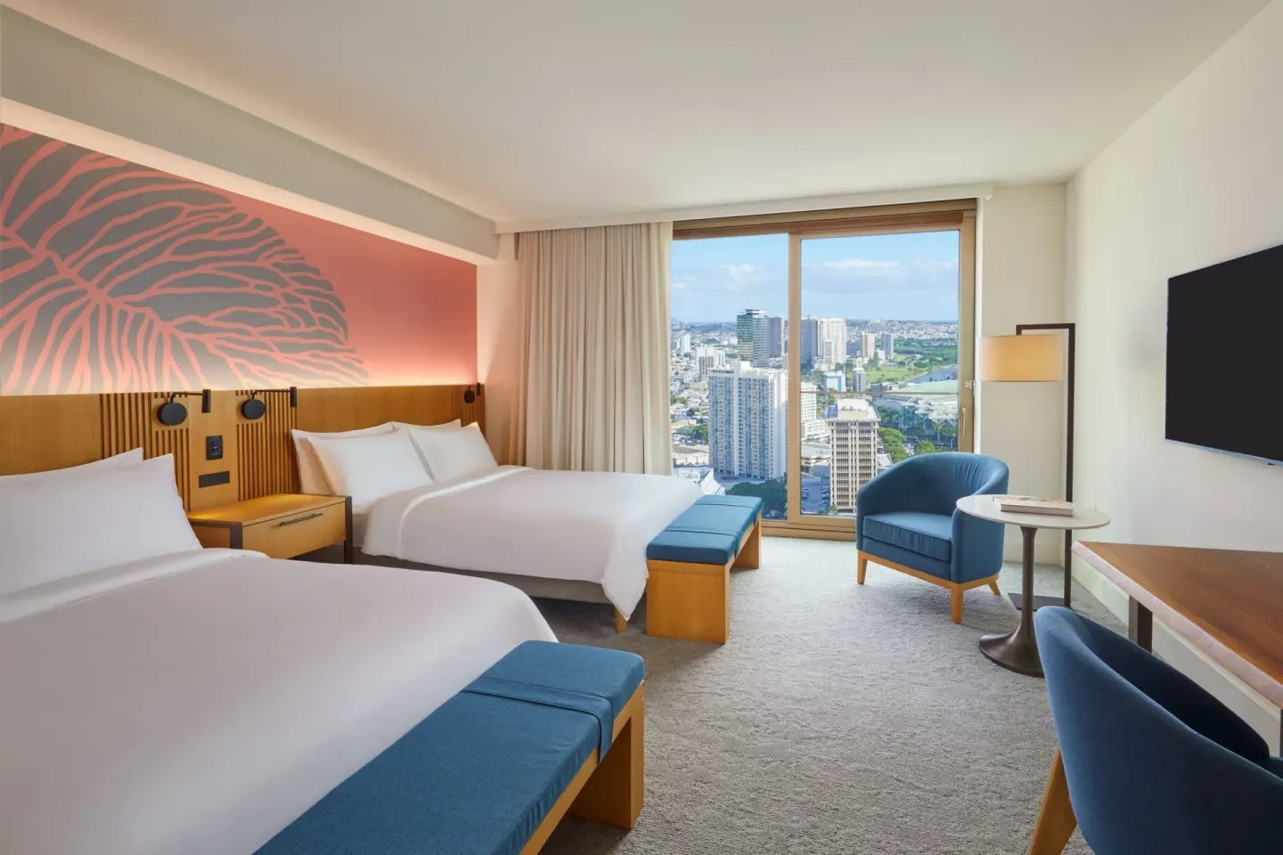 City View guest room at Renaissance Honolulu Hotel & Spa with two beds and window seating by the skyline.