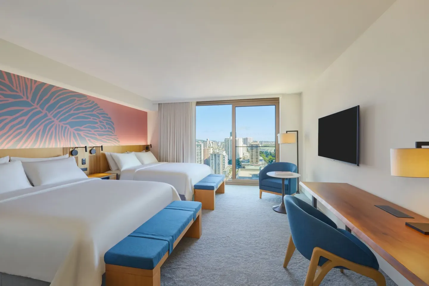 City View guest room at Renaissance Honolulu Hotel & Spa with two beds, desk, TV, and skyline window.