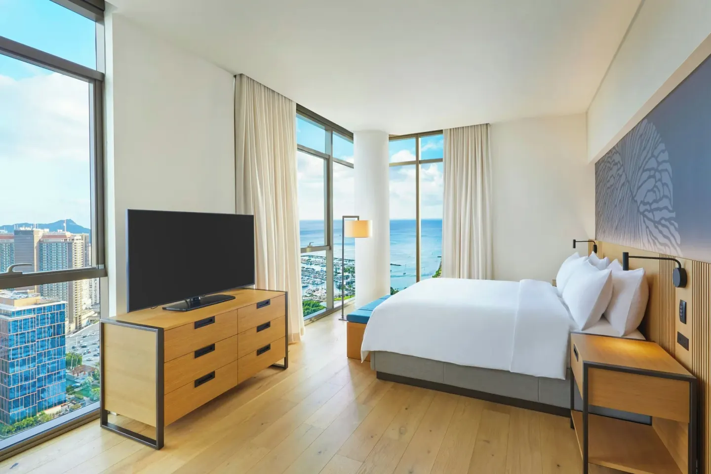 Bedroom with ocean-view windows in the Kaiului Penthouse suite at Renaissance Honolulu Hotel & Spa.