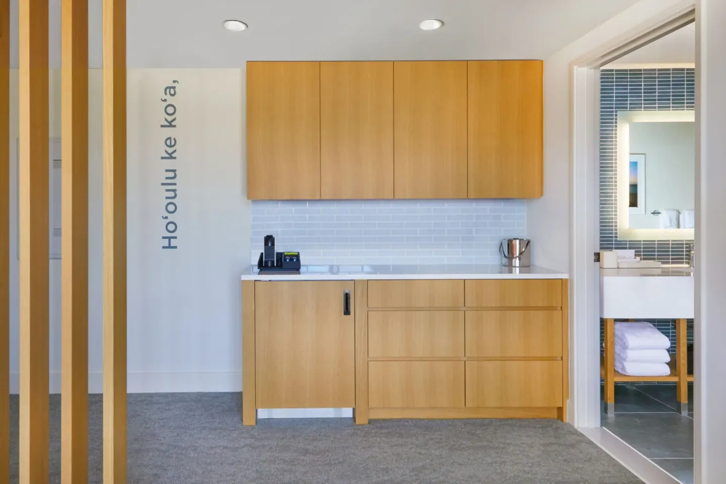 Suite wet bar with wood cabinetry and bathroom doorway at Renaissance Honolulu Hotel & Spa.