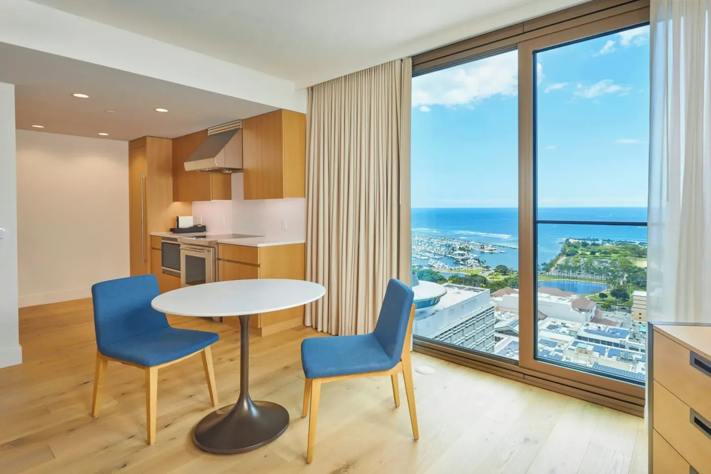 Dining area and kitchen in an Ocean View suite at Renaissance Honolulu Hotel & Spa overlooking the ocean.