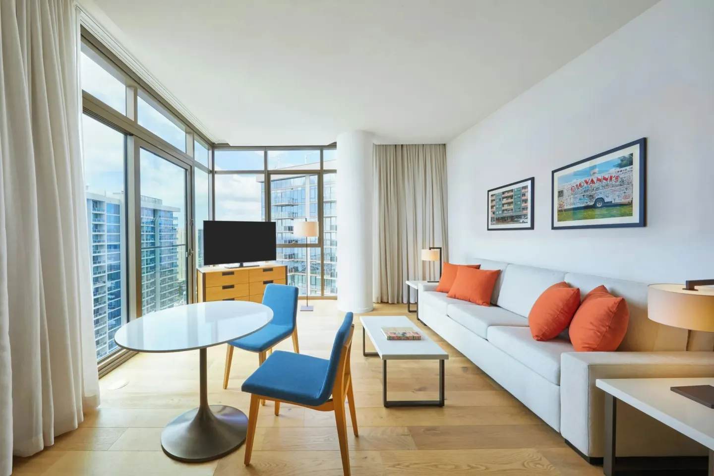 Living area in an Ocean View one-bedroom suite at Renaissance Honolulu Hotel & Spa with sofa and windows.