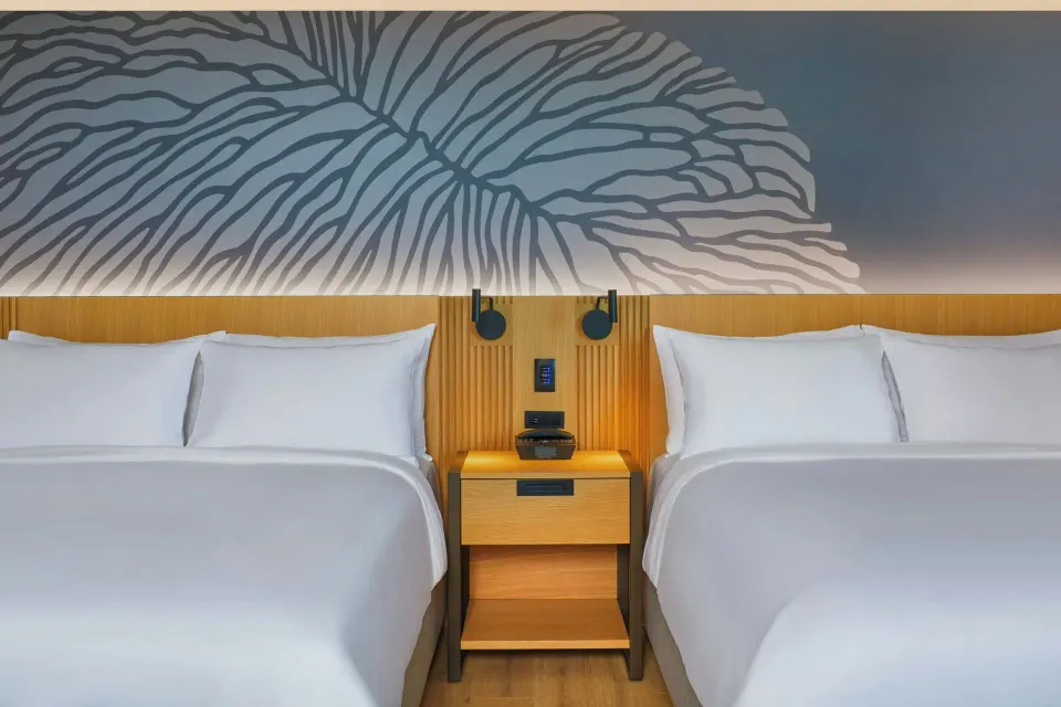 Two beds and shared nightstand in an Ocean View Residence room at Renaissance Honolulu Hotel & Spa.