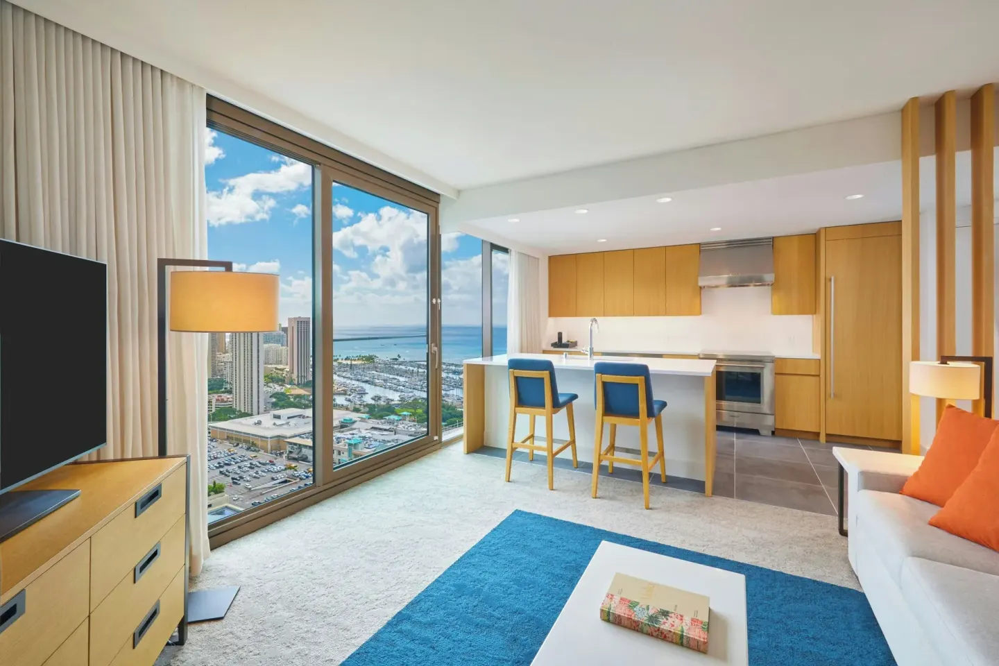 Suite living room with kitchen, TV, and ocean view at Renaissance Honolulu Hotel & Spa.