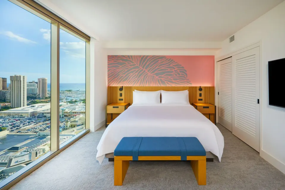 Panoramic View one bedroom suite king bed at Renaissance Honolulu Hotel & Spa with ocean and city windows.