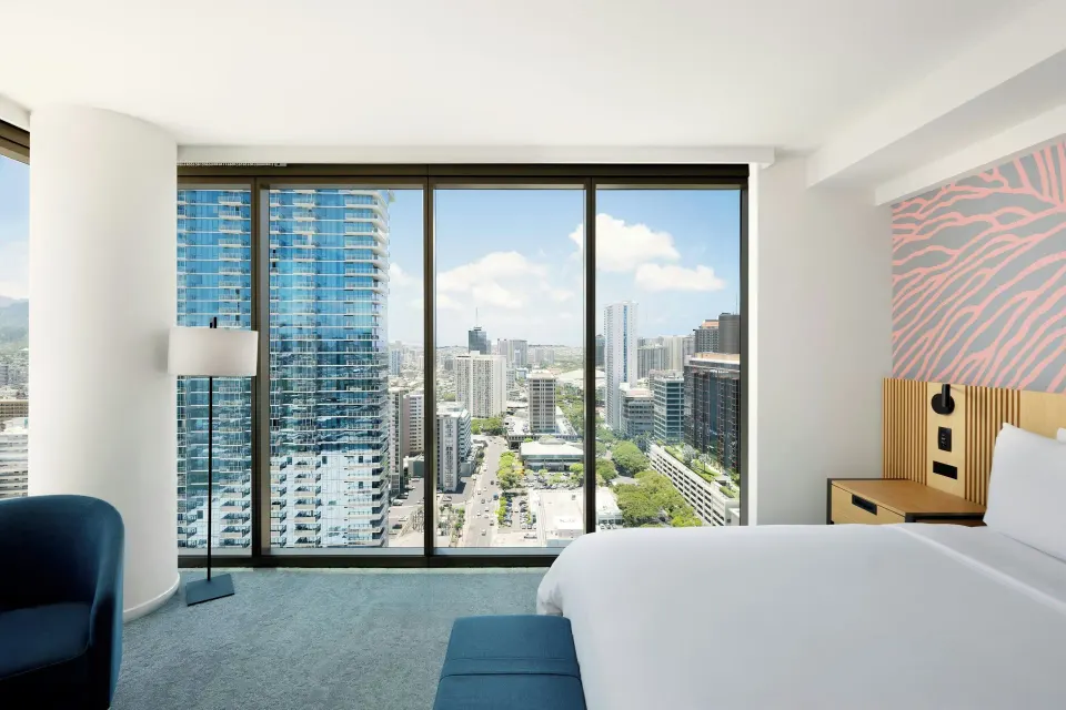 Panoramic View suite bedroom at Renaissance Honolulu Hotel & Spa with king bed and skyline windows.