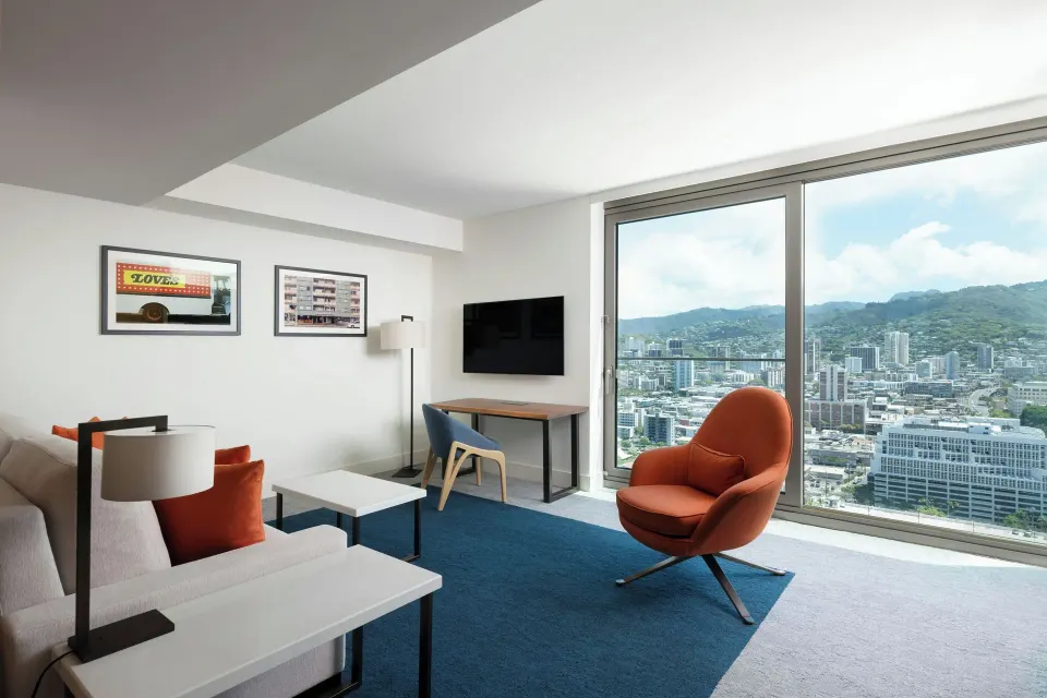 Panoramic View 1 Bedroom Suite sitting area at Renaissance Honolulu Hotel & Spa with mountain skyline windows.