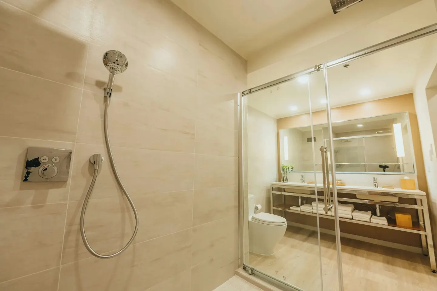 Bathroom with glass shower, vanity and toilet at Renaissance Wind Creek Aruba Resort.
