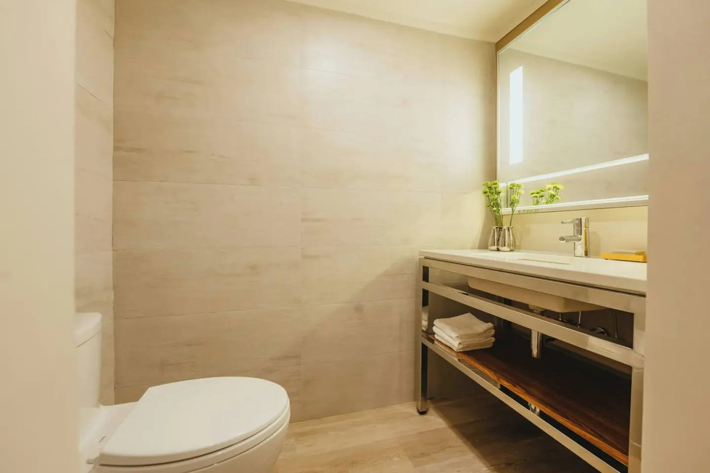 Bathroom vanity and toilet with lighted mirror at Renaissance Wind Creek Aruba Resort.
