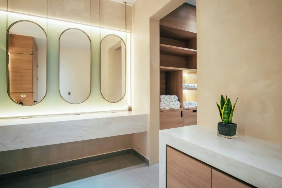 Spa vanity area with arched mirrors and rolled towels at Renaissance Wind Creek Aruba Resort.